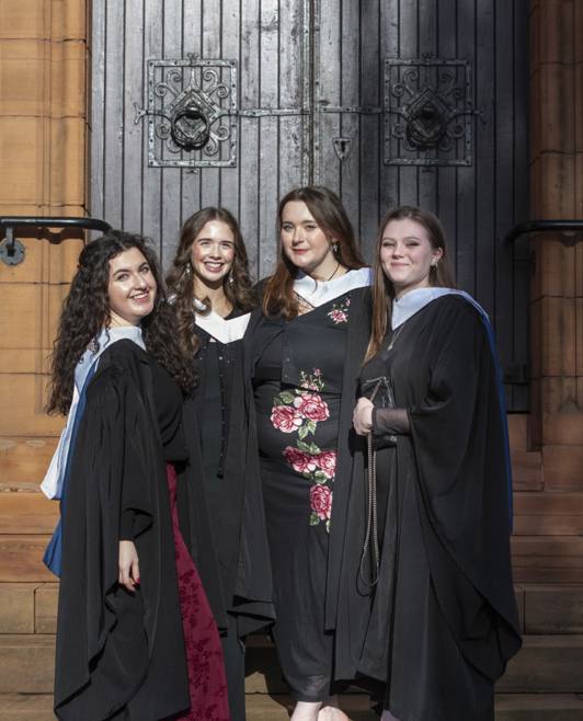 4 female graduates outside main entrance 4 female graduates outside main entrance